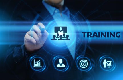 Businessperson tapping on a digital interface with icons for growth, goal achievement, personnel, and presentation; the word “TRAINING” in the center.