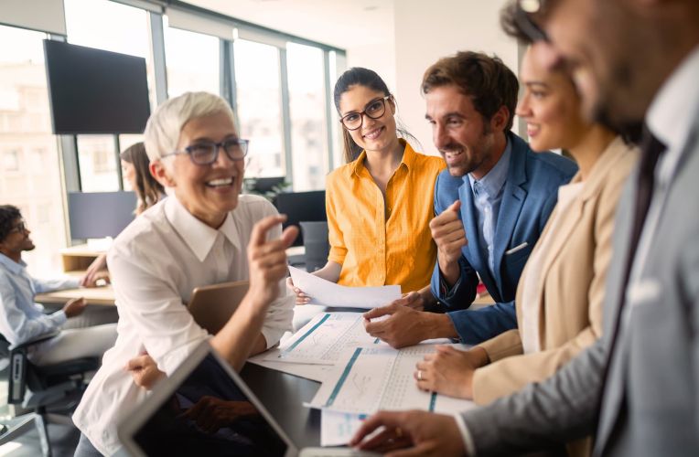 A team of women and men talk about their work.