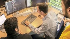 For the digitization of public administration, three AKQUINET employees examine the source code of a software.