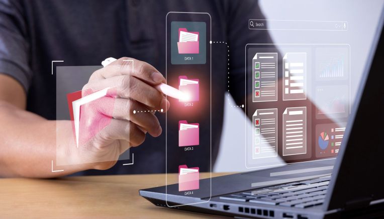 File management is symbolized imaginarily with folders. Laptop and hands can be seen.